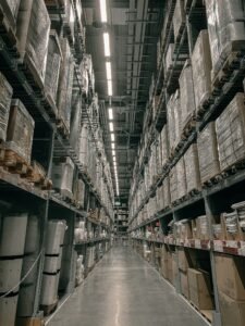 Warehouse aisle lined with tall pallet racking and stacked goods