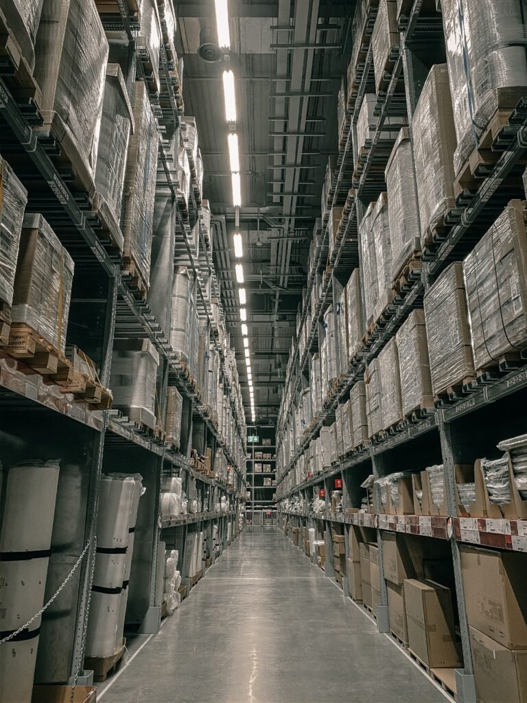 Warehouse aisle lined with tall pallet racking and stacked goods