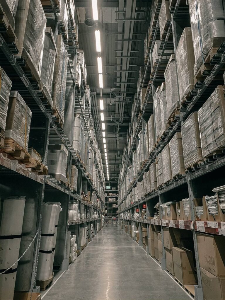 Warehouse aisle lined with tall pallet racking and stacked goods